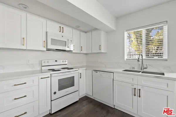 a kitchen with cabinets appliances a sink and a white cabinets