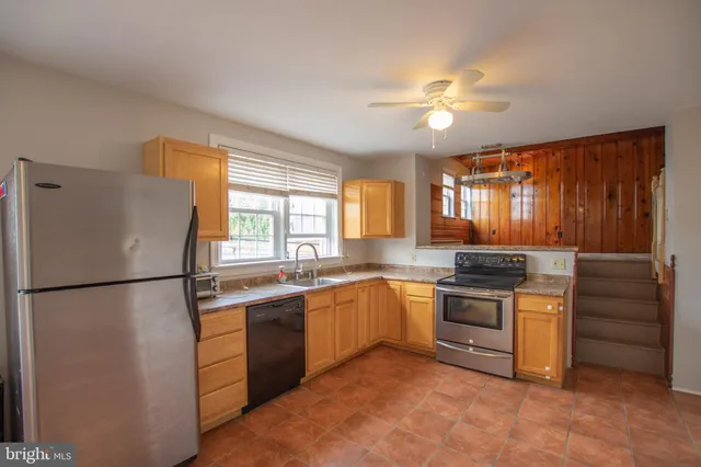 a kitchen with stainless steel appliances granite countertop a stove a refrigerator and a sink