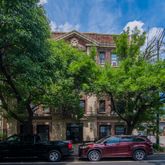 a front view of a building with trees