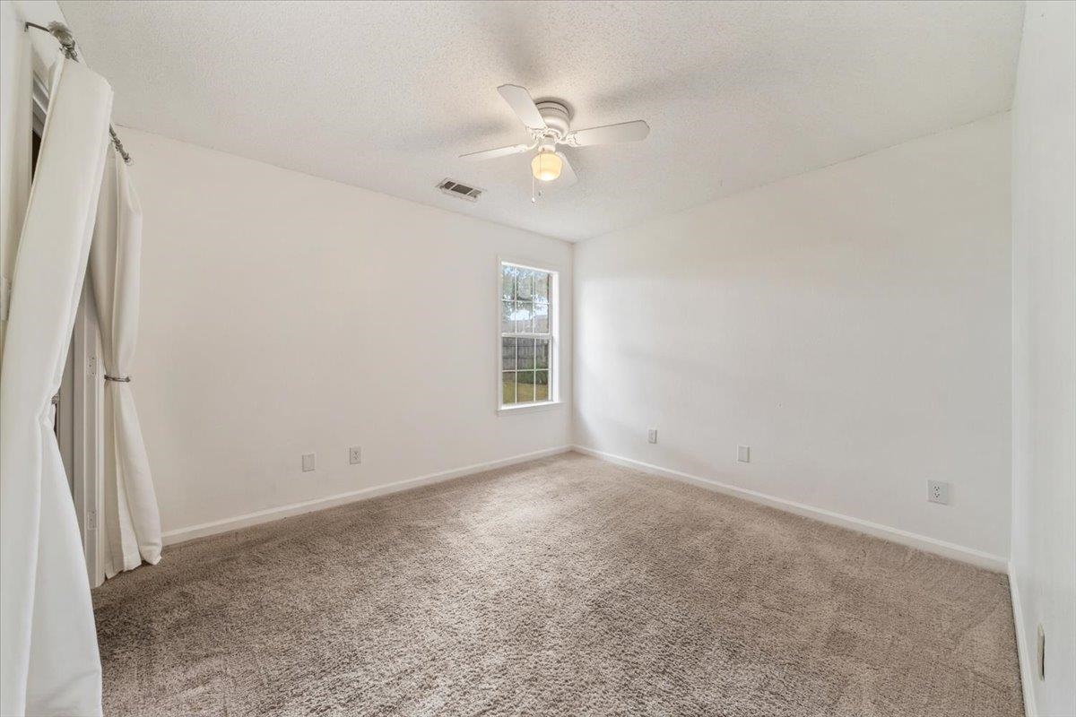 1279 River Ridge Drive Collierville, TN 38017 - Photo 17 of 28 an empty room with a chandelier fan and windows