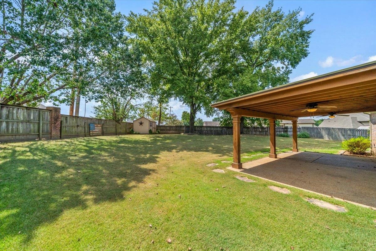 1279 River Ridge Drive Collierville, TN 38017 - Photo 22 of 28 a backyard of a house with table and chairs under an umbrella
