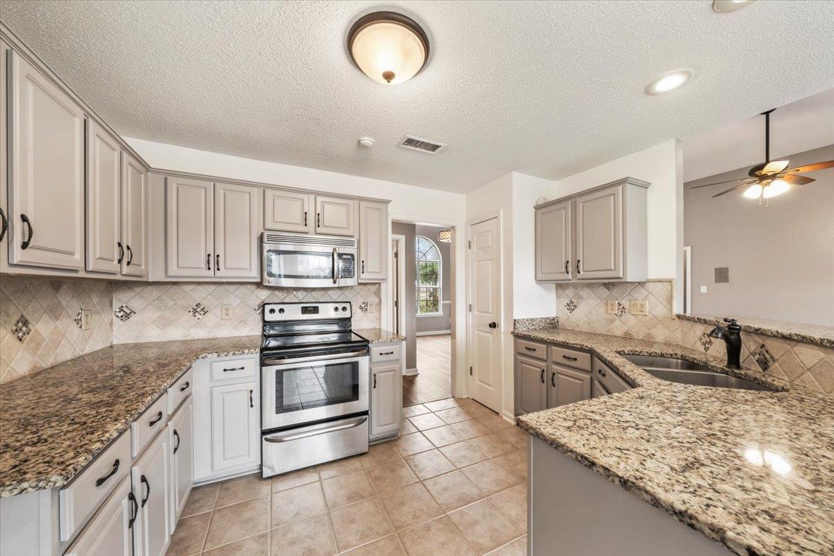 1279 River Ridge Drive Collierville, TN 38017 - Photo 9 of 28 a kitchen with stainless steel appliances granite countertop a sink stove and refrigerator
