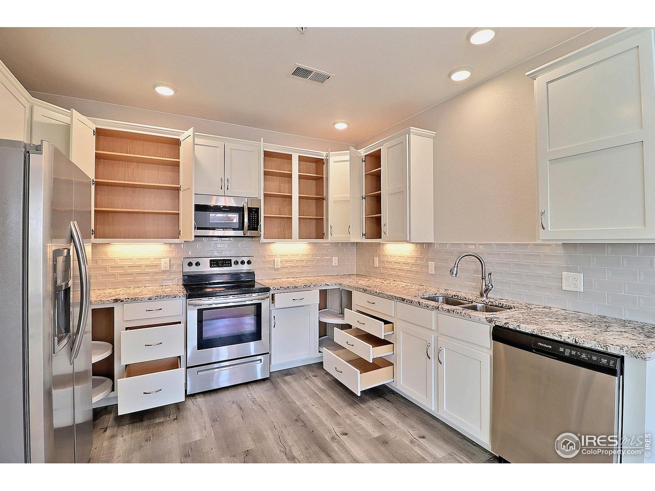 4672 West 20th Road, Unit 525 Greeley, CO 80634 - Photo 13 of 35 a kitchen with stainless steel appliances granite countertop a refrigerator and a stove top oven
