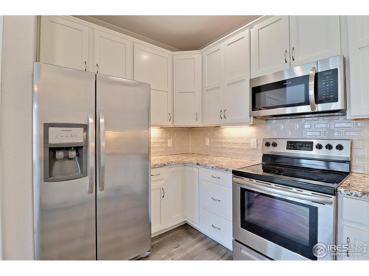 4672 West 20th Road, Unit 525 Greeley, CO 80634 - Photo 15 of 35 a kitchen with stainless steel appliances granite countertop a stove a refrigerator and a microwave