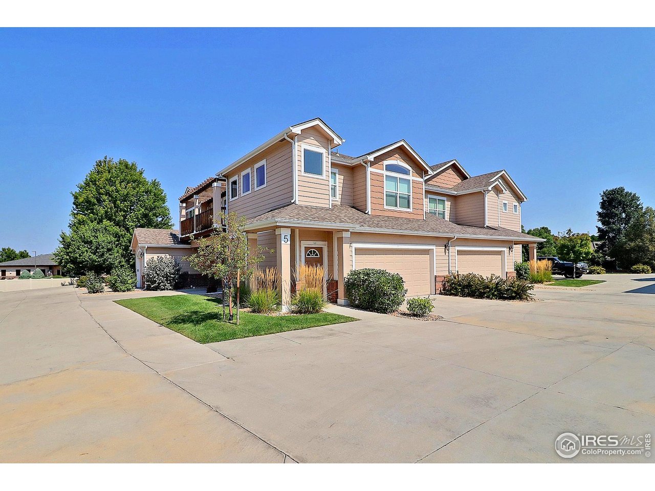 4672 West 20th Road, Unit 525 Greeley, CO 80634 - Photo 2 of 35 a front view of a house with a yard and garage