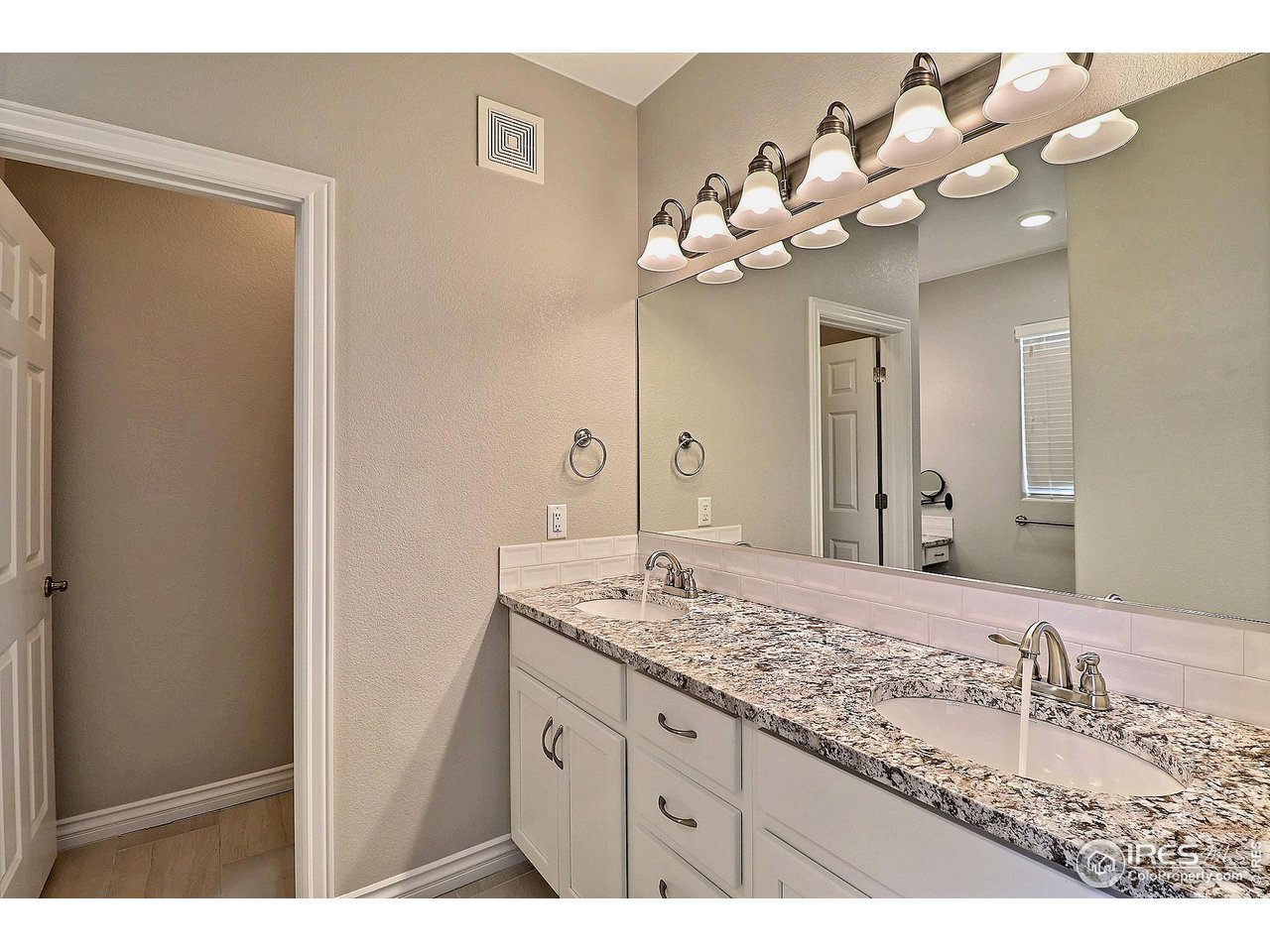 4672 West 20th Road, Unit 525 Greeley, CO 80634 - Photo 22 of 35 a bathroom with a granite countertop sink a large mirror and a shower