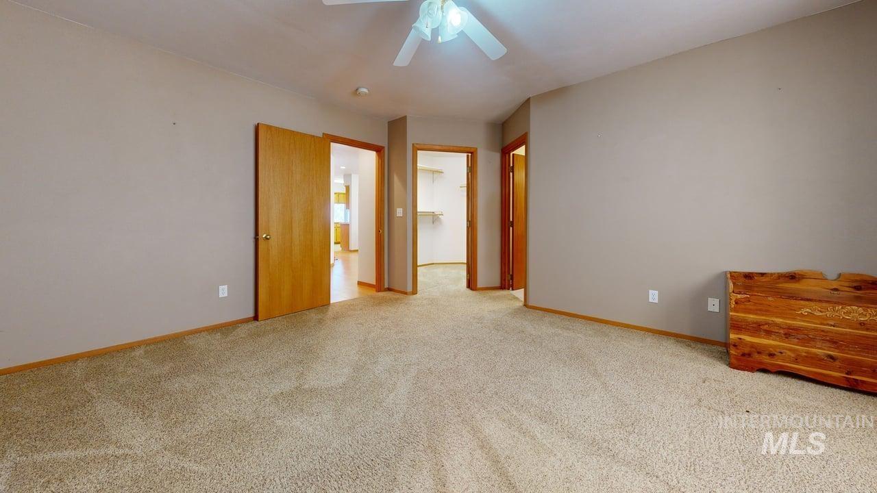 2794 9th Avenue Clarkston, WA 99403 - Photo 25 of 34 Unfurnished bedroom with a spacious closet, light colored carpet, and ceiling fan