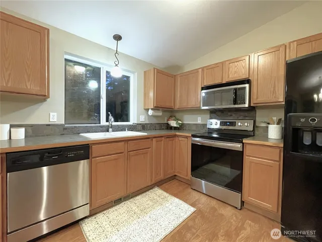 a kitchen with stainless steel appliances granite countertop a refrigerator and a stove top oven