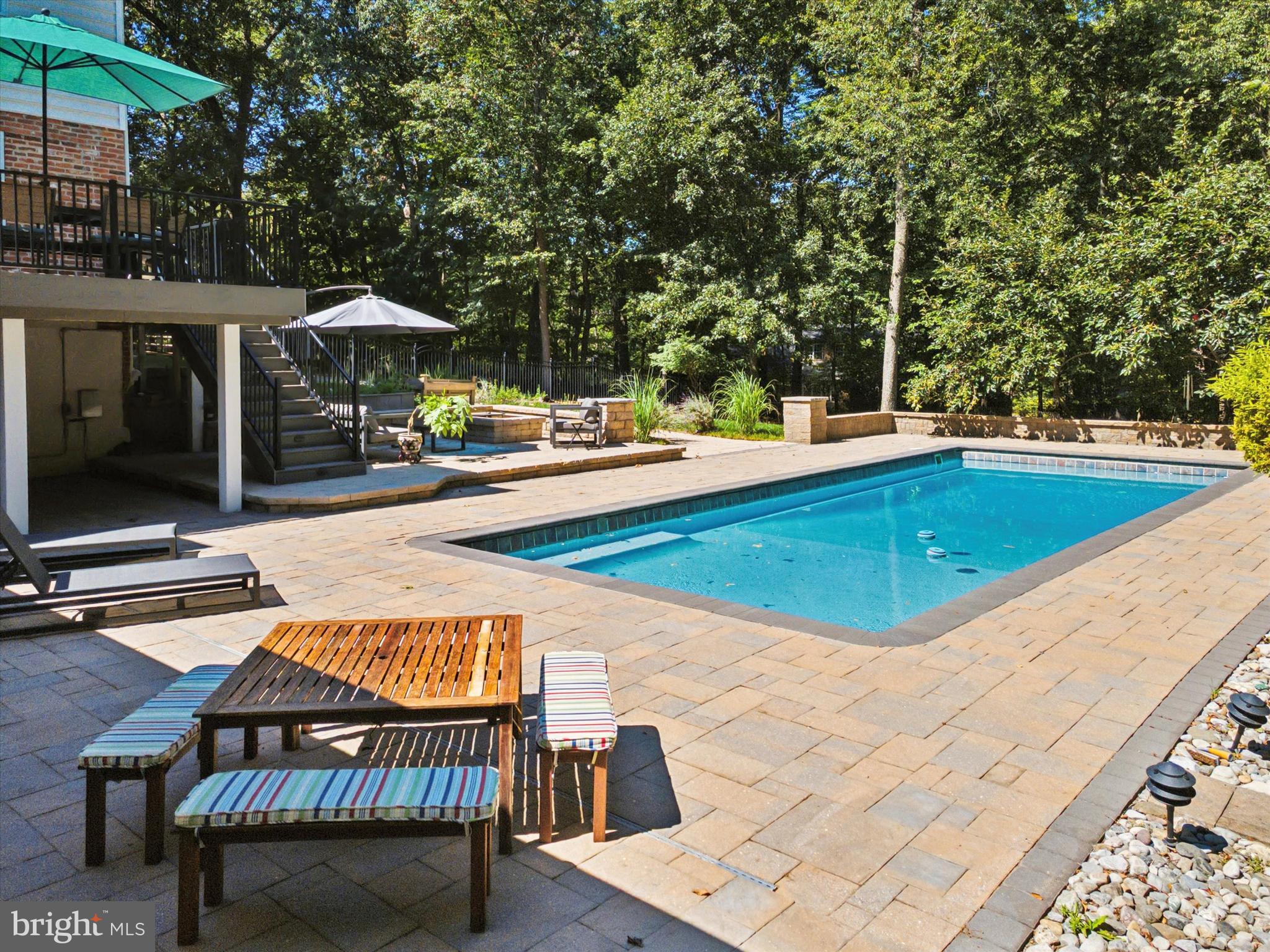 570 Fletcher Road Wayne, PA 19087 - Photo 13 of 54 a view of a swimming pool with a table and chairs under an umbrella