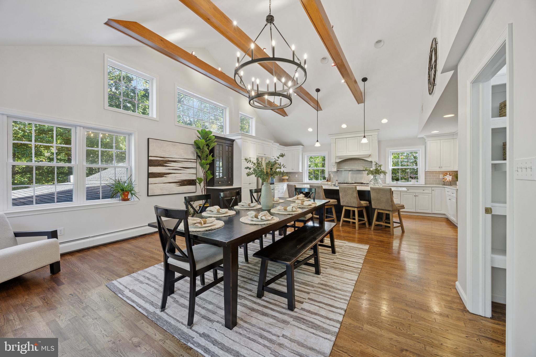 570 Fletcher Road Wayne, PA 19087 - Photo 28 of 54 a dining room with wooden floor a chandelier a wooden table and chairs