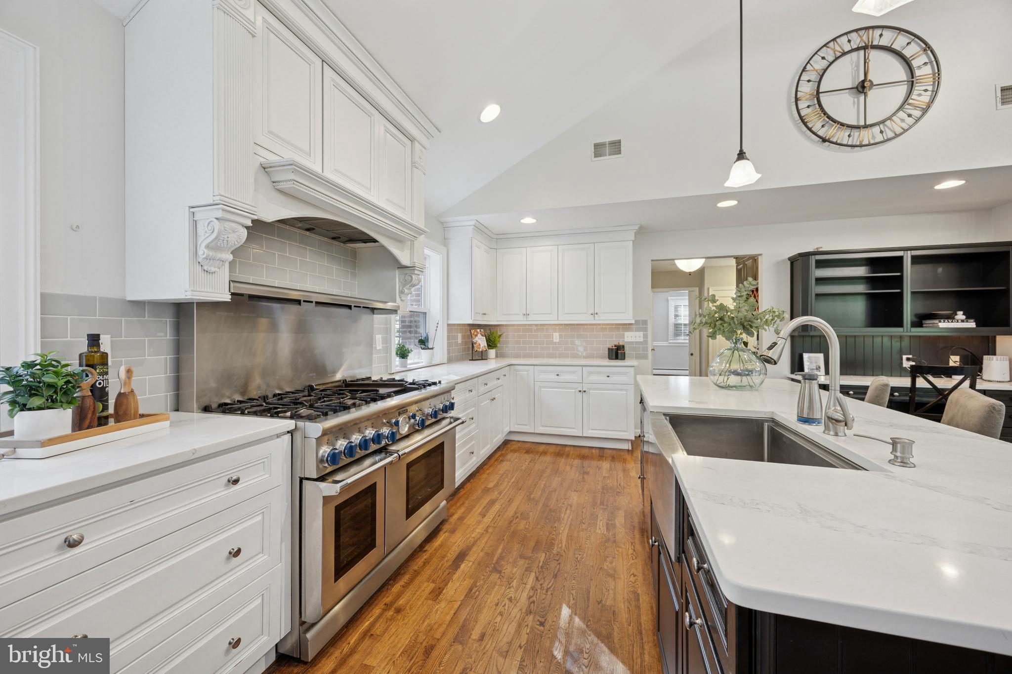 570 Fletcher Road Wayne, PA 19087 - Photo 34 of 54 a large kitchen with stainless steel appliances granite countertop a stove a sink a refrigerator and white cabinets with wooden floor