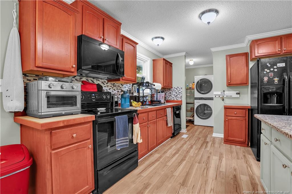 8155 Arabia Road Lumber Bridge, NC 28357 - Photo 11 of 30 a kitchen with stainless steel appliances a stove top oven a sink dishwasher and a fireplace with wooden floor