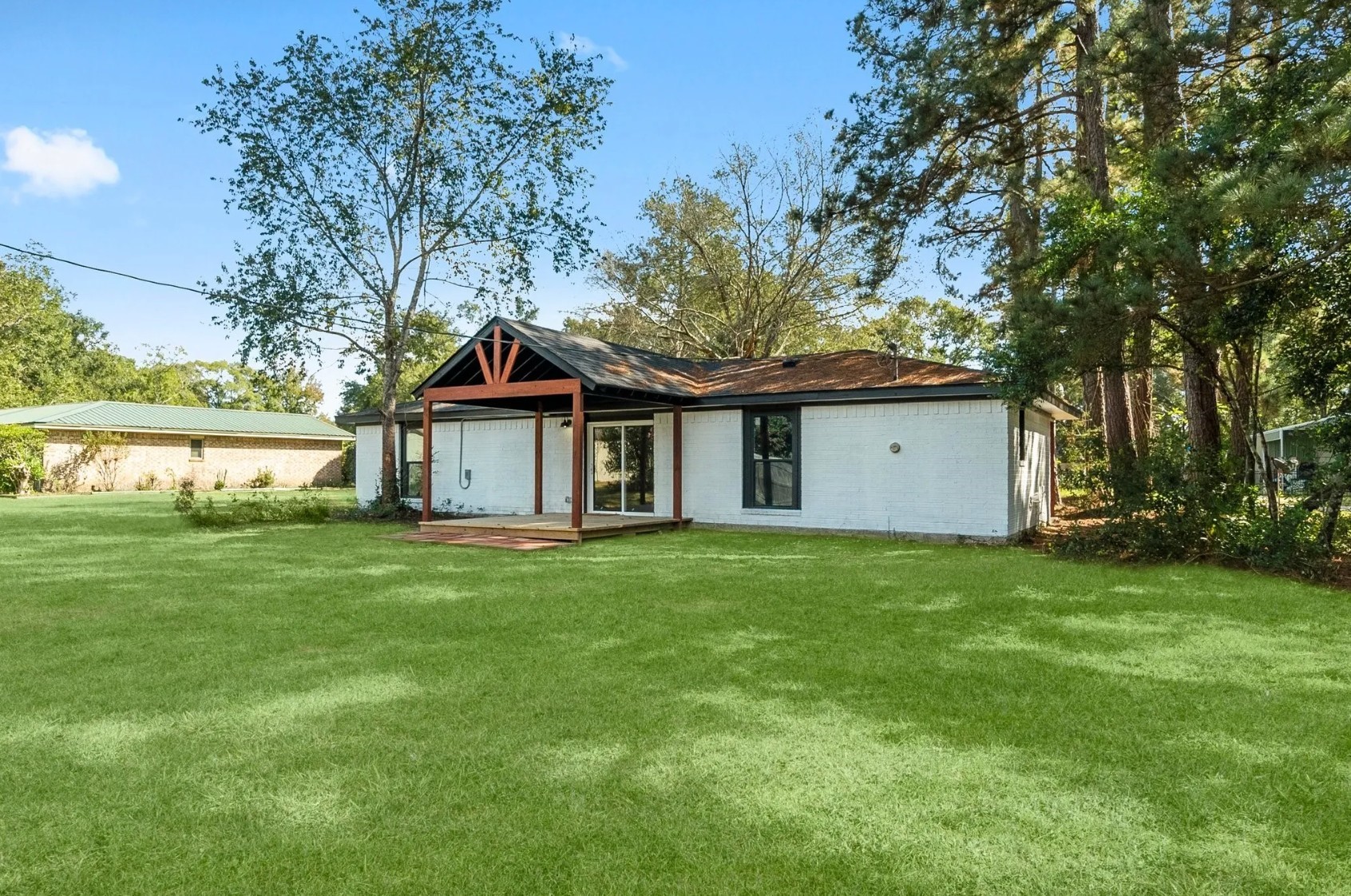 Discover the charm of this inviting home with its sleek design, nestled within a lush, expansive yard with mature trees, offering a perfect blend of comfort and nature.