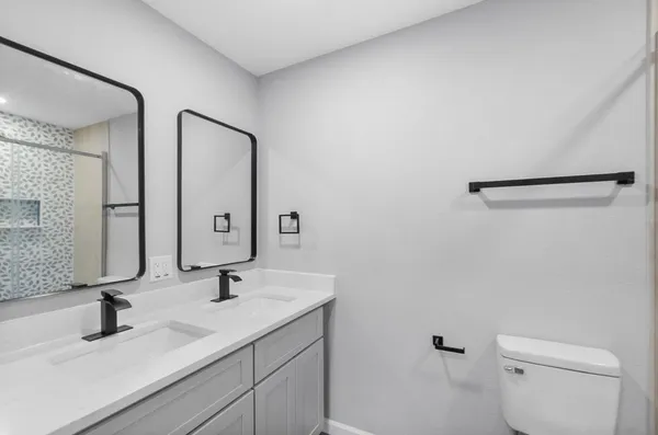 a bathroom with a double vanity sink and mirror