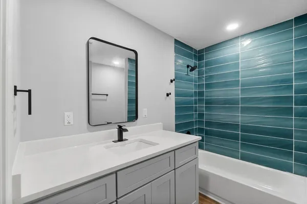 a bathroom with a sink toilet a mirror and shower