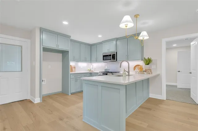 a kitchen with kitchen island granite countertop a sink a stove and a refrigerator