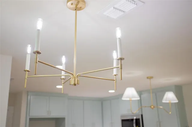 a view of a room with furniture and a chandelier fan