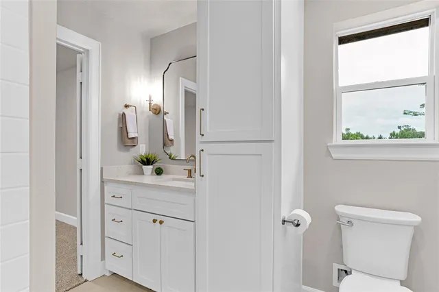 a bathroom with a sink and mirror with toilet