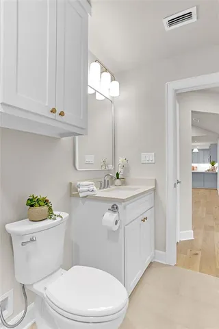 a bathroom with a sink vanity mirror and toilet