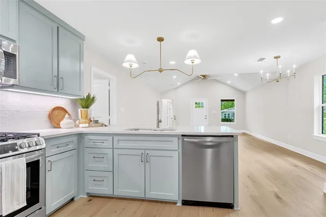 a kitchen with white cabinets and appliances