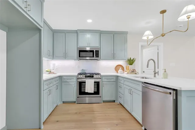 a kitchen with white cabinets appliances and a sink