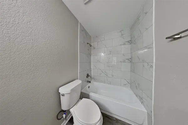 a white toilet and tub sitting next to a bathroom sink