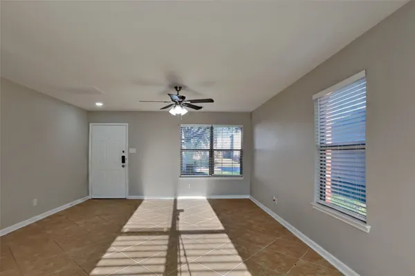 a view of a room with a ceiling fan and window