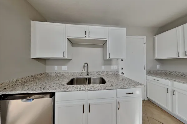 a kitchen with stainless steel appliances granite countertop a sink and a white cabinets