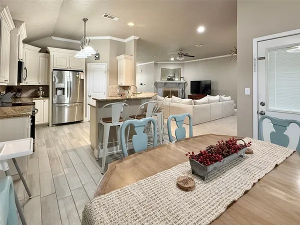 a kitchen with kitchen island a counter top space a sink stainless steel appliances and cabinets