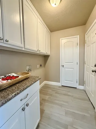 a kitchen with granite countertop white cabinets and stainless steel appliances