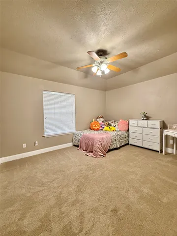 a bed room with bed and a ceiling fan