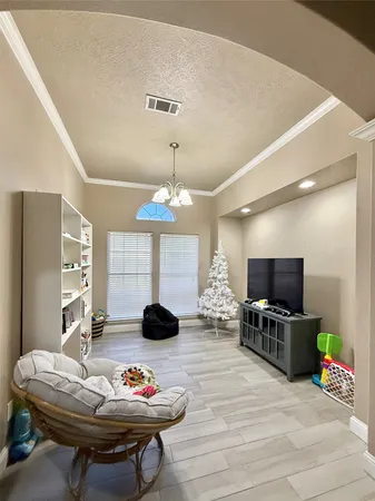 a living room with patio furniture and a flat screen tv