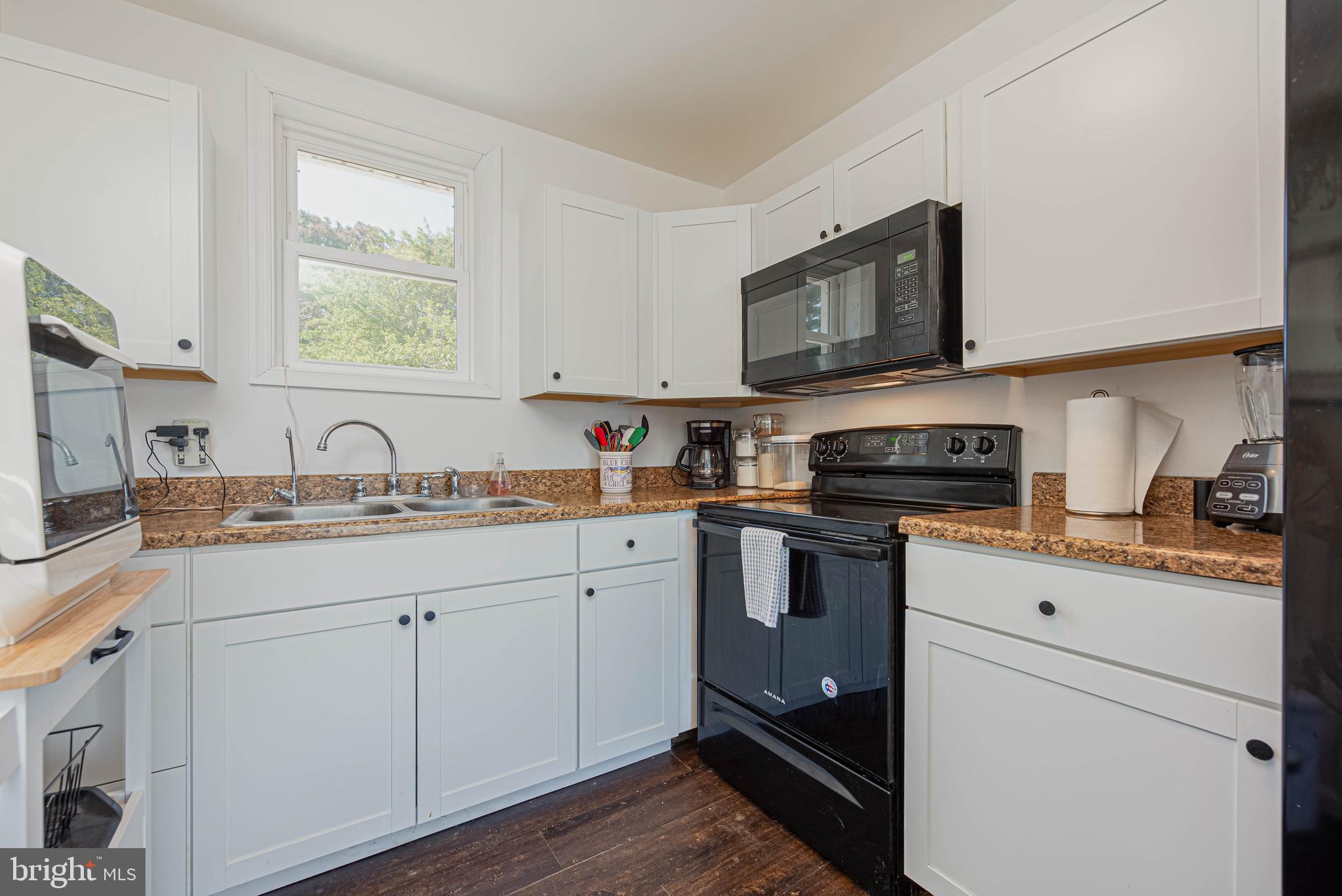 11152 Roland Parks Road Deal Island, MD 21821 - Photo 16 of 42 a kitchen with stainless steel appliances granite countertop a sink dishwasher a stove and a microwave oven with cabinets