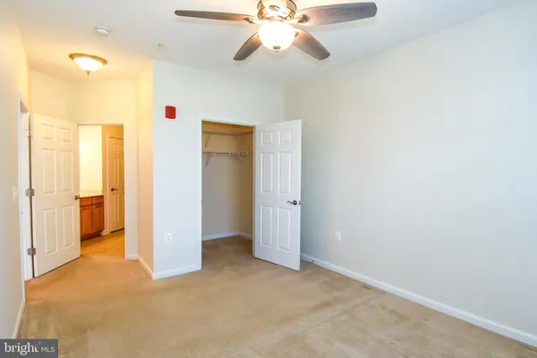 a view of a room with a ceiling fan and closet area