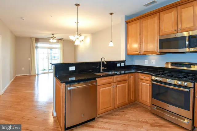 a kitchen with granite countertop a stove a sink and a microwave