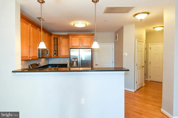 a kitchen with stainless steel appliances granite countertop a refrigerator a sink and a stove