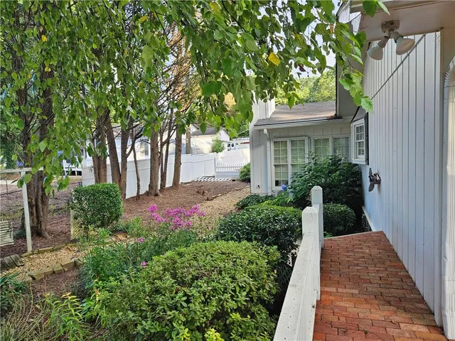 a view of house with a yard and potted plants
