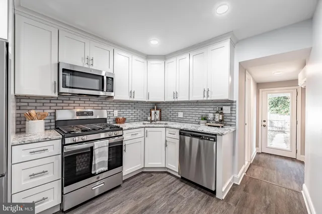a kitchen with stainless steel appliances granite countertop a stove and a sink