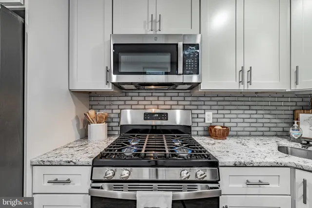 a stove top oven sitting inside of a kitchen