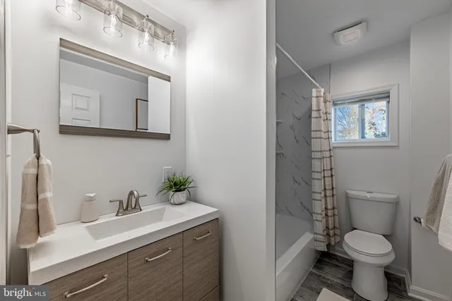 a bathroom with a toilet a sink and mirror