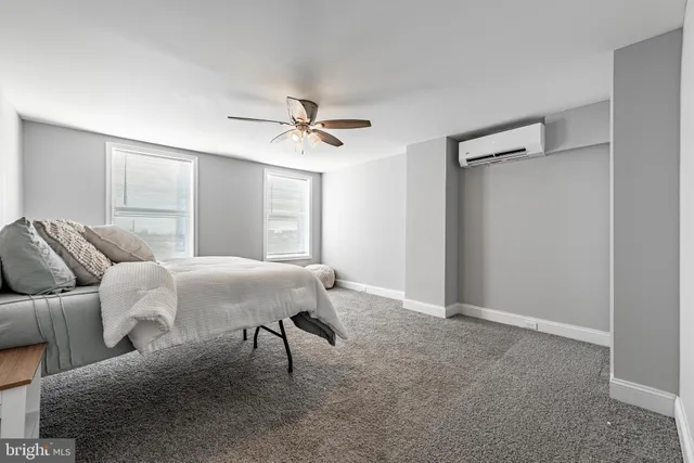 a living room with furniture and a ceiling fan