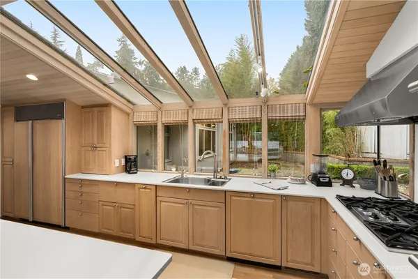 a kitchen with stainless steel appliances granite countertop a stove a sink and a refrigerator with white cabinets