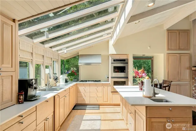 a large white kitchen with granite countertop a sink and a large window