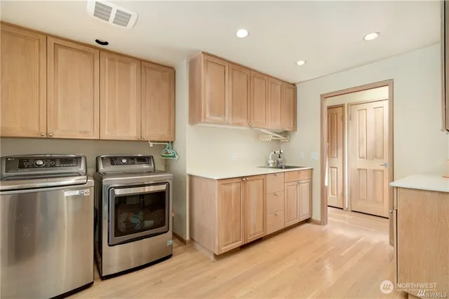 a kitchen with stainless steel appliances granite countertop a stove a sink and a refrigerator with white cabinets
