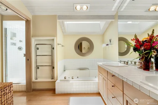 a bathroom with a tub sink and mirror