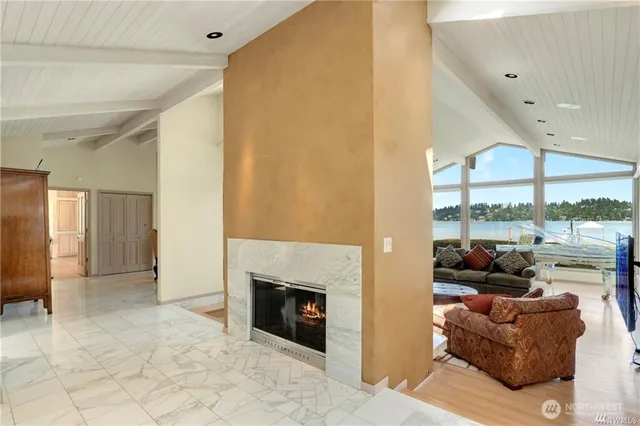 a living room with furniture a fireplace and a large window