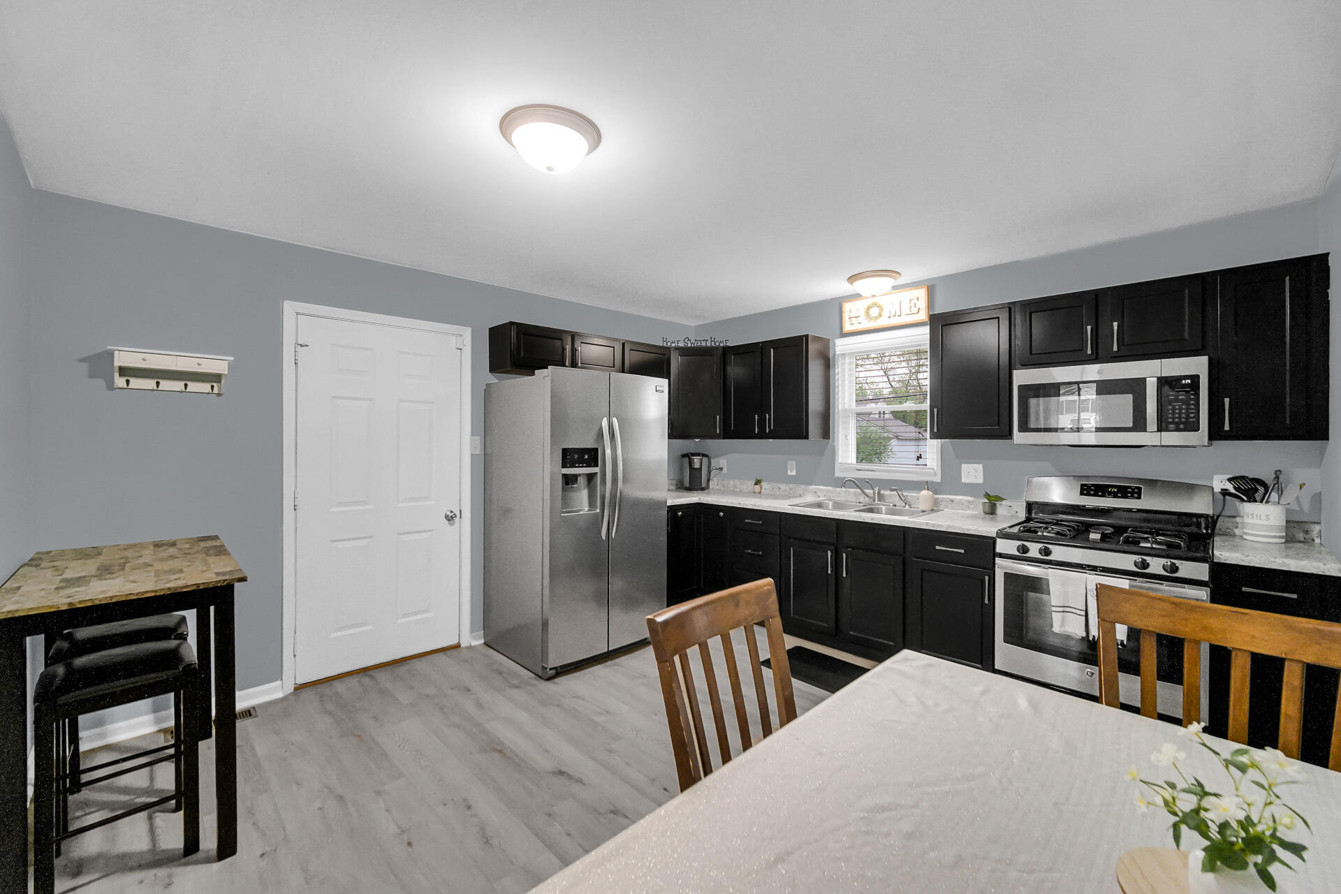 705 Juniper Road Valparaiso, IN 46385 - Photo 5 of 21 a kitchen with stainless steel appliances granite countertop a refrigerator a stove top oven a sink dishwasher and white cabinets with wooden floor