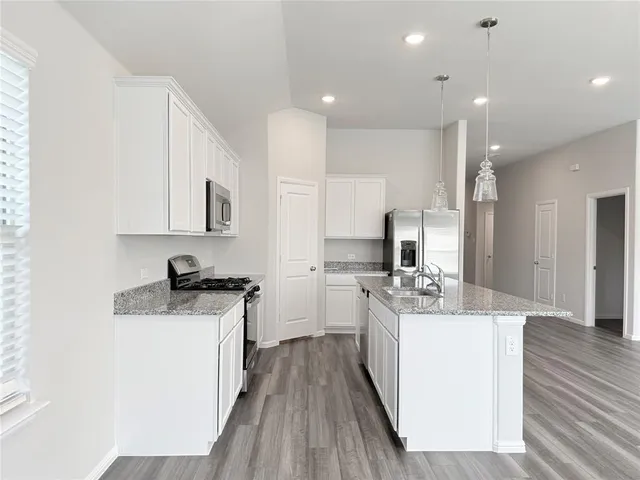 a kitchen with a stove a sink and a refrigerator