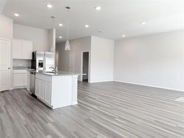 a kitchen with stainless steel appliances kitchen island wooden floors and white cabinets