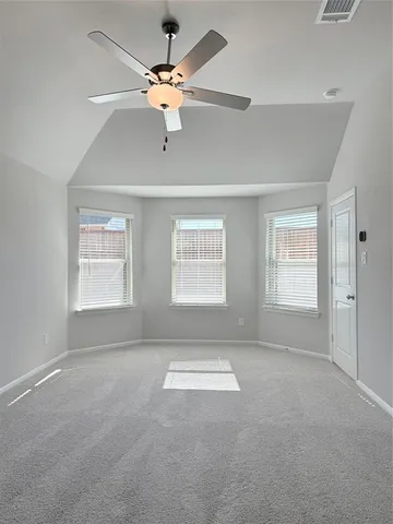 an empty room with windows and fan